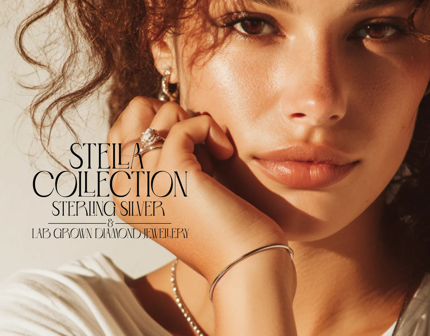 Woman Wearing Earrings face on hand with ring on finger and with text Stella Collection on light background