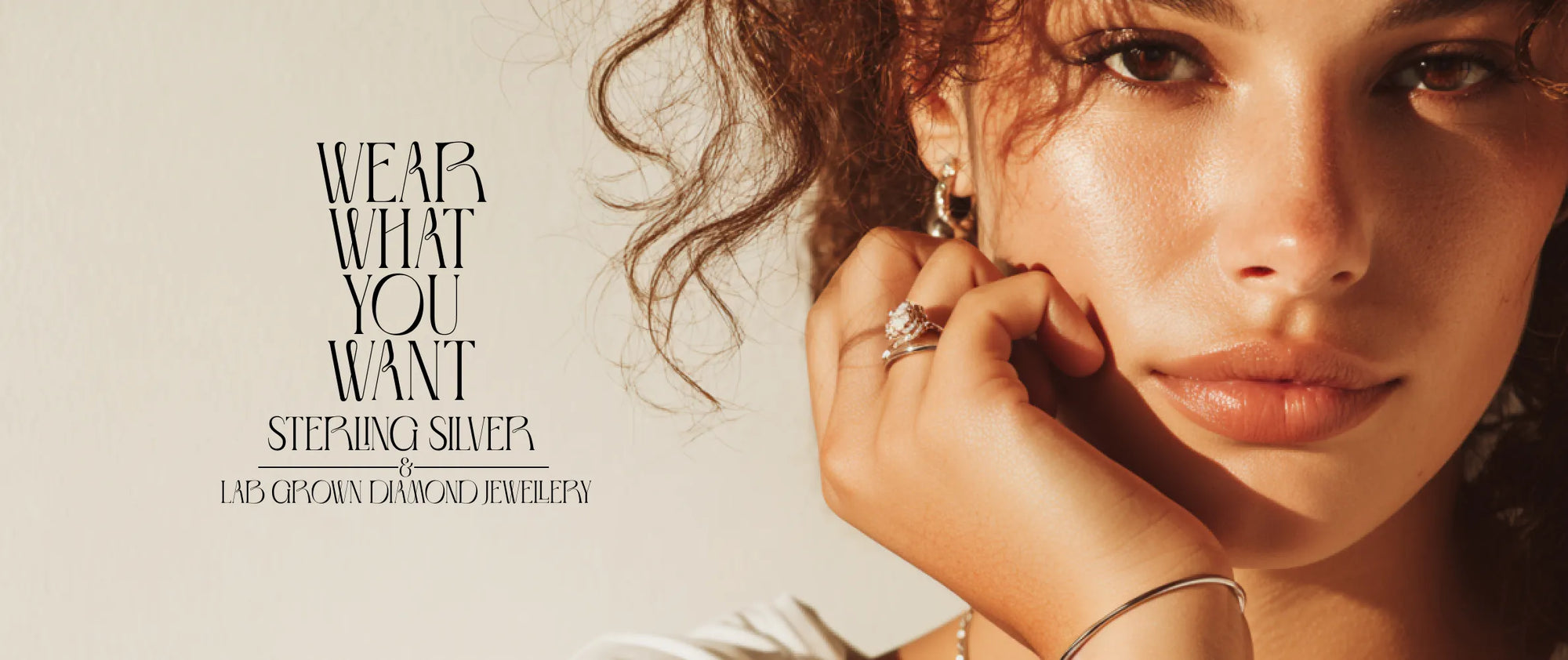 Close-up of a woman adjusting an earring with 'Stephie Silver' jewelry brand text.