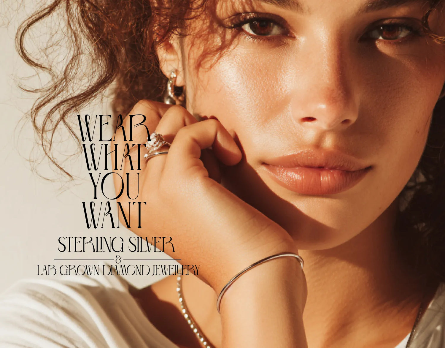 Woman wearing jewelry with text 'Wear What You Want' and brand name.
